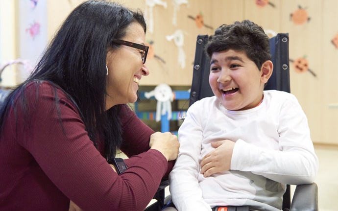 BCCH patient, Omar with a caregiver at Sunny Hill Health Centre